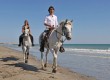 Honeymoon couple horse riding on the beach